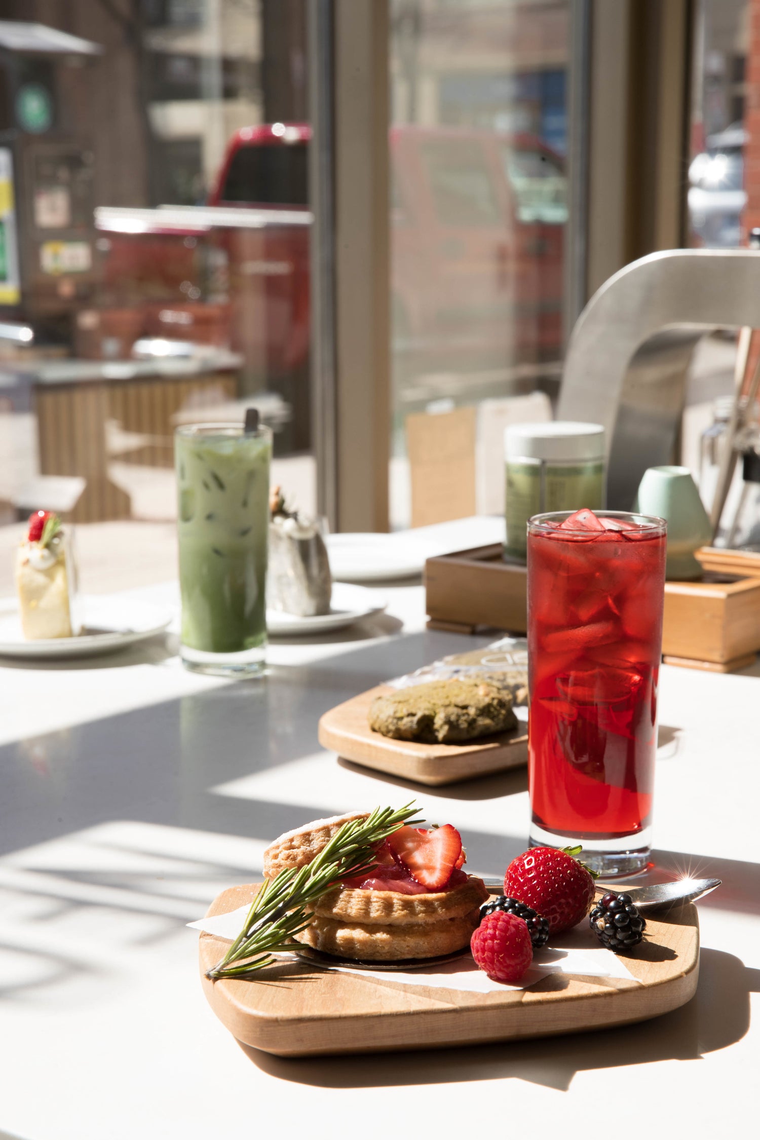 Matcha and tea drinks on a table with pastries. 